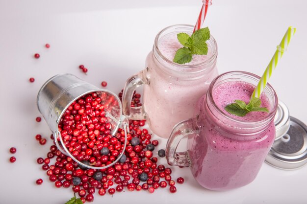 Verschiedene Frucht- oder Beereshakes auf weißem Tisch Smoothie-Konzept