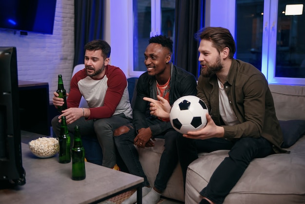 Verschiedene Fußballfans jubeln der Lieblingsmannschaft zu und trinken zu Hause Bier, kopieren Platz