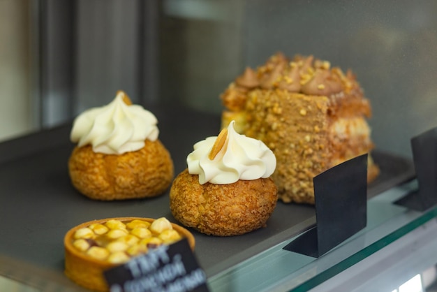 Verschiedene gebackene Shu-Kuchen-Törtchen und Kiewer Kuchen in der Glasvitrine im Bäckerei-Café