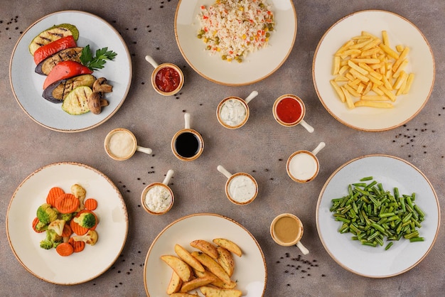 Verschiedene Gerichte: Grillgemüse, Reis mit Gemüse, Pommes frites, gedünstetes Gemüse, Bauernkartoffeln, gedünstete grüne Bohnen.