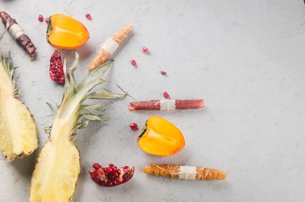 Verschiedene getrocknete Chips und reife Früchte auf grauem Hintergrund. Fruchtchips. Gesundes Ernährungskonzept, Snack, kein Zucker. Ansicht von oben, Kopienraum.