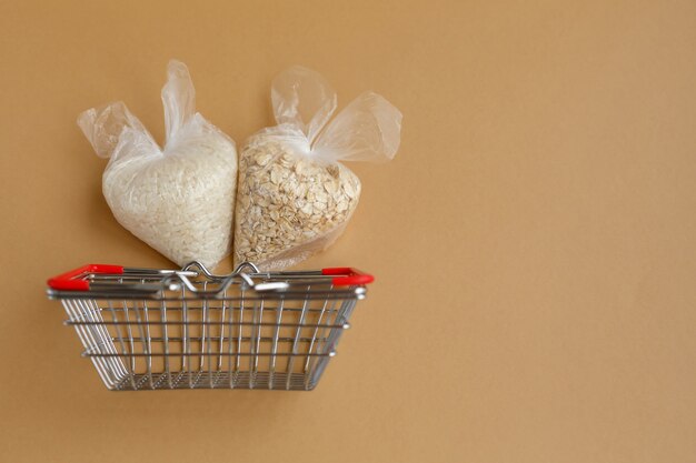Verschiedene Grütze in Paketen im Einkaufskorb Reis und Haferflocken