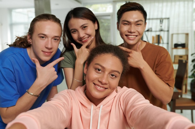 Verschiedene Gruppe lächelnder Teenager, die gemeinsam ein Selfie machen