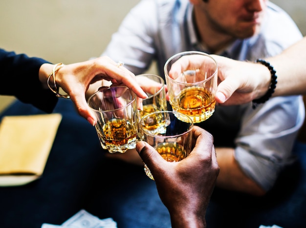 Foto verschiedene hände, die alkoholgläser klirren