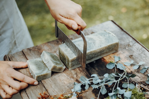 Verschiedene handgemachte Naturseifen auf einem Vintage-Holztisch mit Dekoration