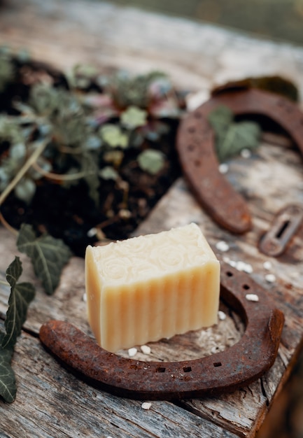 Verschiedene handgemachte Naturseifen auf einem Vintage-Holztisch mit Dekoration