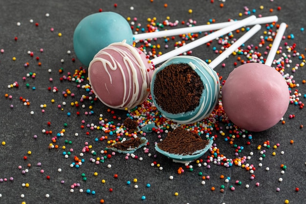 Verschiedene hausgemachte Cake Pops auf dunklem Stein