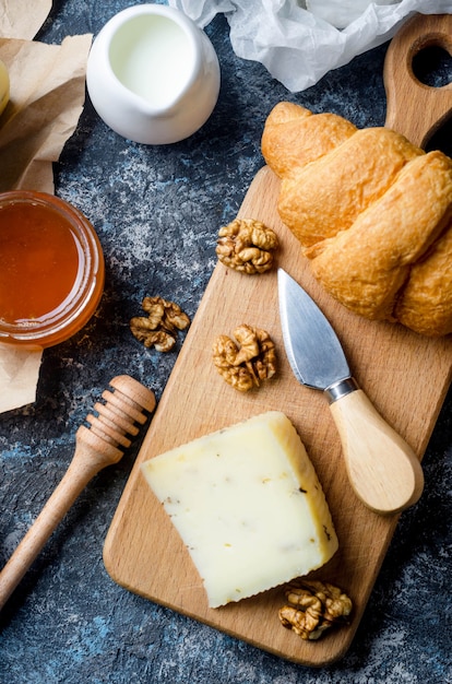 Verschiedene hausgemachte Käsestücke mit Honig, Früchten, Keksen und Nüssen auf dem Tisch. Frisches Milchprodukt, gesunde Bio-Lebensmittel. Leckere Vorspeise.