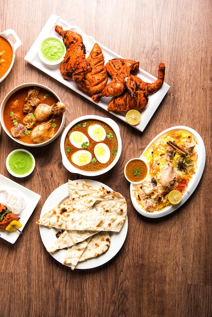Verschiedene indische nicht-vegetarische Speisenrezepte, die in einer Gruppe serviert werden. Enthält Chicken Curry, Mutton Masala, Anda oder Egg Curry, Butter Chicken, Biryani, Tandoori Murg, Chicken-Tikka und Naa, Roti für Ramadan