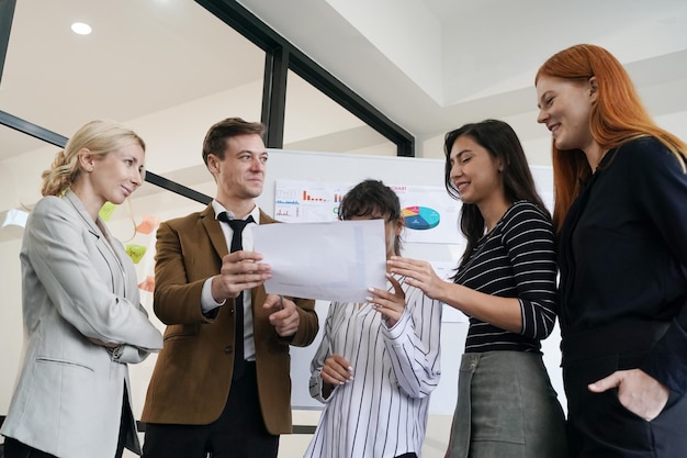 Verschiedene junge Kollegen besprechen Projekte am Schreibtisch im modernen Büro