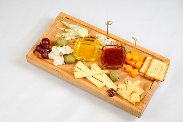 Foto verschiedene käsesorten auf holzschneidebrett, draufsicht.