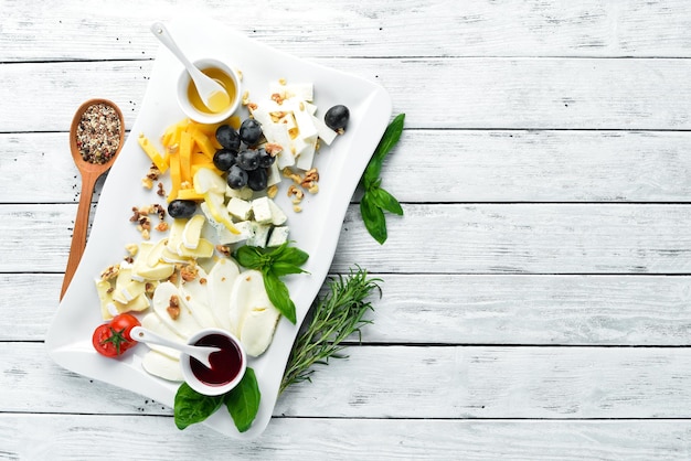 Foto verschiedene käsesorten mit trauben und honig restaurantgerichte draufsicht freier platz für ihren text
