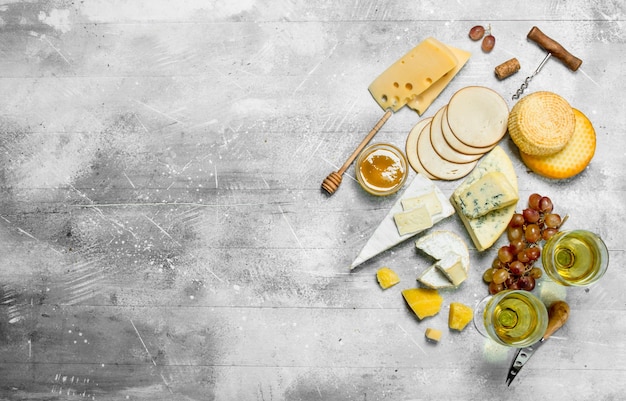 Verschiedene Käsesorten mit Weißwein und Honig