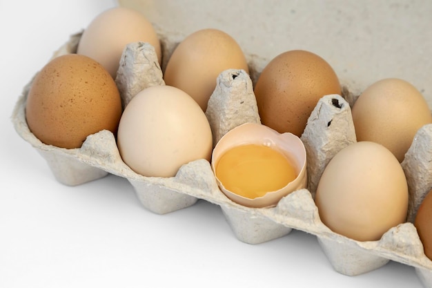 Verschiedene Kategorien von Hühnereiern in einem Kartonbehälter zerbrochenes Hühnerei Eierschale mit Eigelb