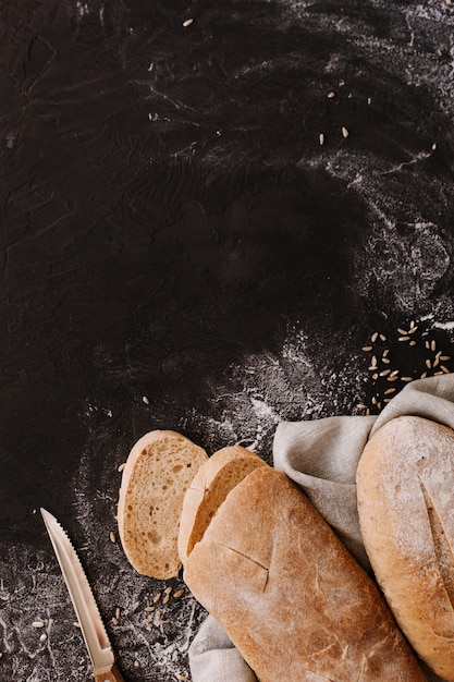 Verschiedene knusprige Brote und Brötchen auf Steintisch