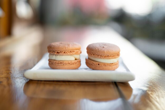 Verschiedene köstliche Macaron-Kekse auf einem quadratischen Plattenständer