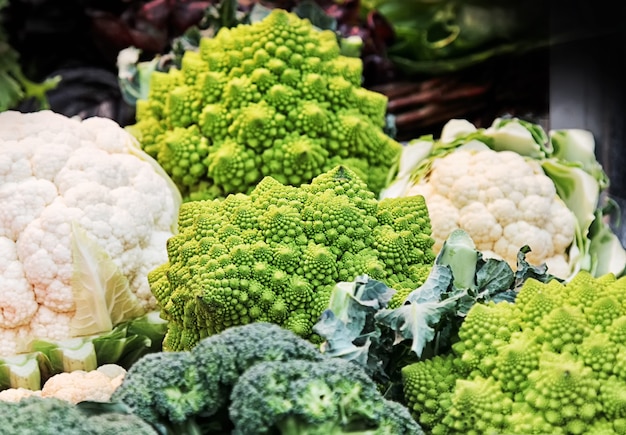 Verschiedene Kohlsorten (Romanesco, Brokkoli, Blumenkohl) in einem Korb auf dem Markt.