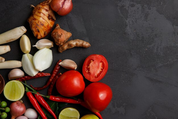 Verschiedene Kräuter und Zutaten zum Kochen auf dunklem Hintergrund.