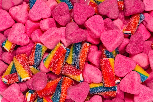 Verschiedene leckere Gummibonbons. Ansicht von oben. Rosa Geleebonbons Hintergrund.