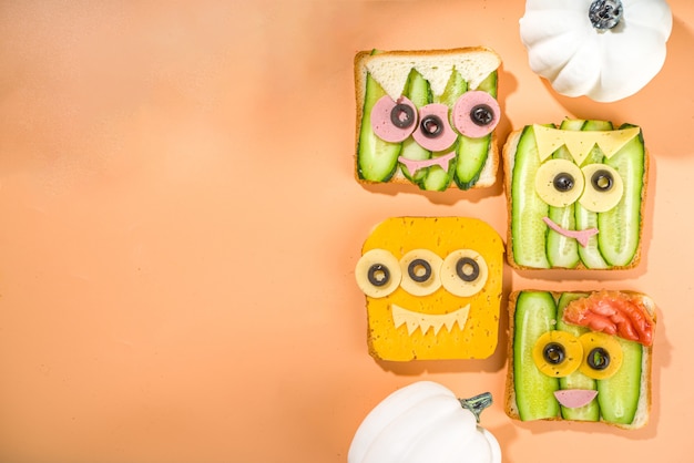 Verschiedene lustige Monster-Halloween-Sandwiches. Set Sortiment kreative Frühstücks-Snack-Toasts mit Käse, Halloween-Kinderparty-Essen, Draufsicht