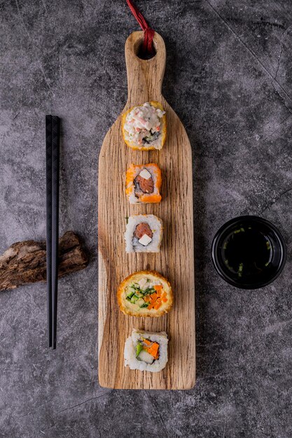 Verschiedene Maki-Sushi auf Holzplatte, japanisches Essen im Restaurant