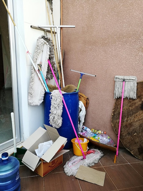 Verschiedene Mops im Behälter gegen die Wand