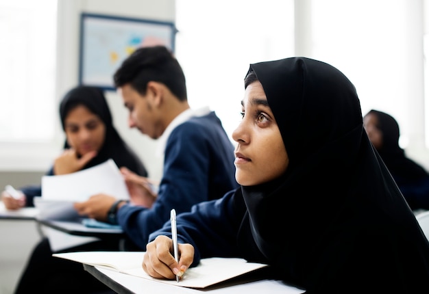 Verschiedene moslemische Kinder, die im Klassenzimmer studieren
