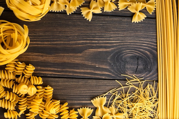 Verschiedene Nudelmischungen auf dunklem Holztisch. italienisches Essen