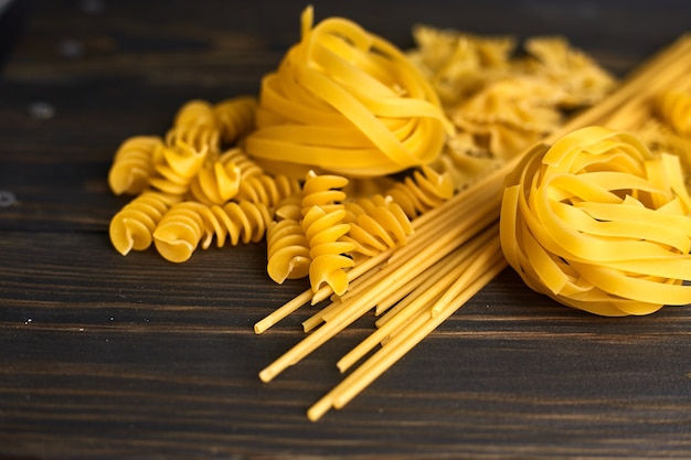 Foto verschiedene nudelmischungen auf dunklem holztisch. italienisches essen