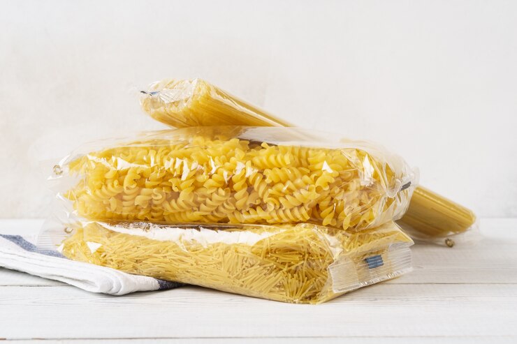 Verschiedene Nudeln in transparenten Plastiktüten auf einem Küchentisch. Lebensmittel. Spaghetti, Fusilli und Fadennudeln.
