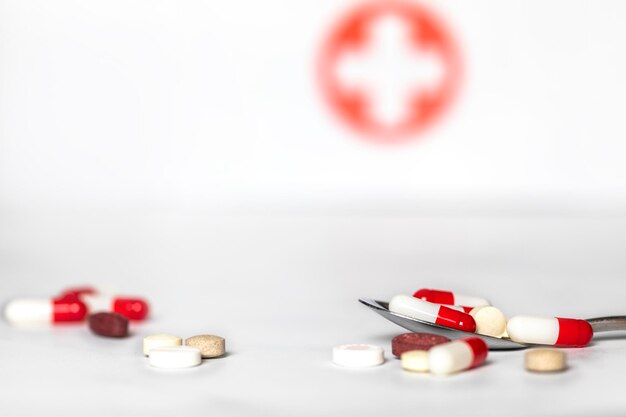 Verschiedene pharmazeutische Medizinpillen, Tabletten und Kapseln auf Löffelapothekenhintergrund mit Kopie s