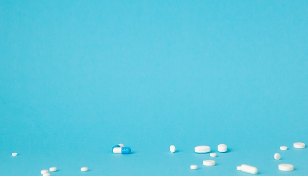 Verschiedene pharmazeutische Medizinpillen, Tabletten und Kapseln über der blauen Wand