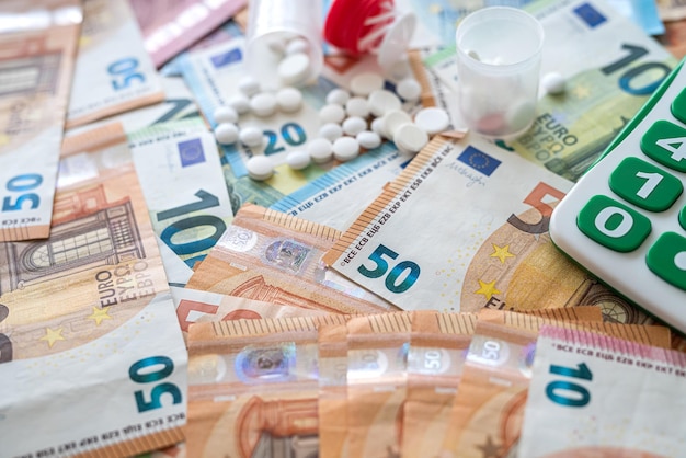 Verschiedene Pillenrechner und Euro-Banknoten medizinisches Konzept kostenintensive Apotheke