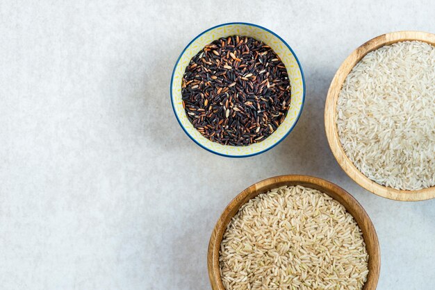 Verschiedene Reissorten in Holzschalen wie Basmati braun u