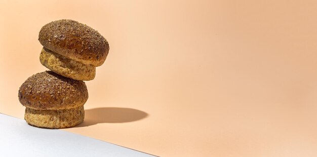 Verschiedene runde hausgemachte Brioche-Brötchen mit Samen auf einem bunten Hintergrund mit kontrastreichem Licht