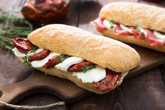 Verschiedene Sandwiches. Sandwich Caprese mit Mozzarella und sonnengetrockneten Tomaten und Ciabatta mit Schinken