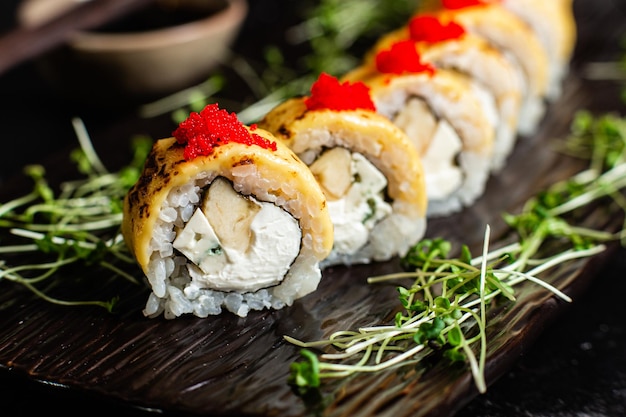 Foto verschiedene sushi-rollen auf dunklem hintergrund