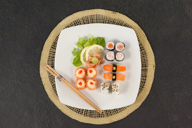 Verschiedene Sushi-Sets mit Essstäbchen auf Sushi-Matte