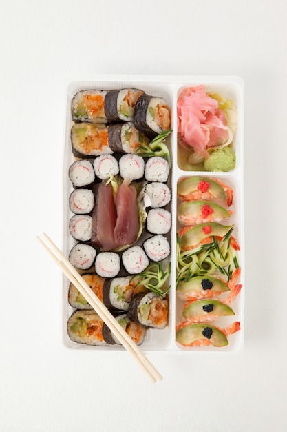 Verschiedene Sushi-Sets mit Essstäbchen in weißer Schachtel