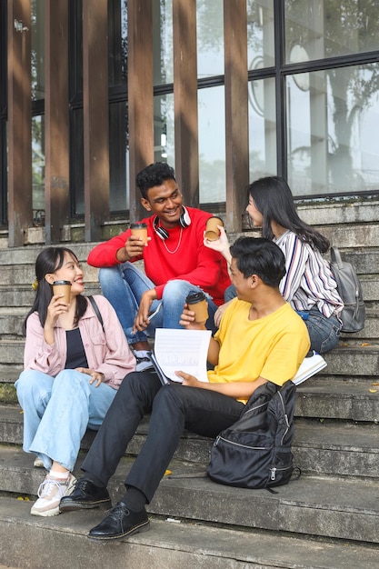 Verschiedene tausendjährige junge College-Studenten lächeln und genießen angenehme Gespräche im Campus-Treppenhaus