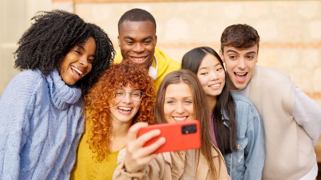 Foto verschiedene teenager, die sich draußen lächelnd und lachend ein selfie machen