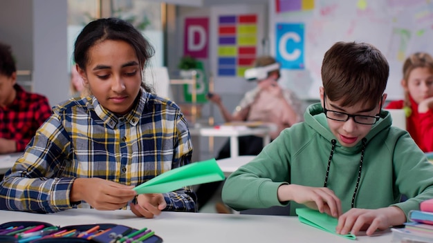 Verschiedene Teenager machen Origami im Klassenzimmer der Schule