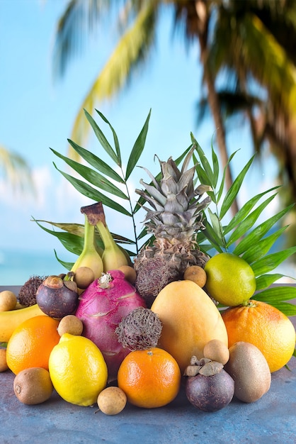 Verschiedene tropische Früchte am Strand Orange, Ananas, Limette, Mango, Drachenfrucht, Orange, Banan, Rambutan und Lichi