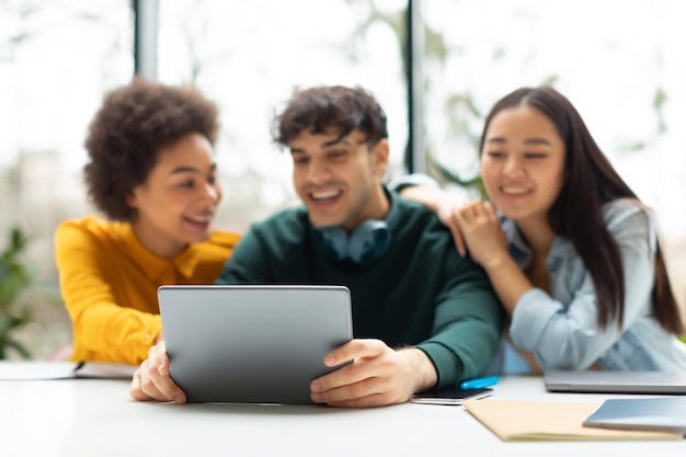 Verschiedene Universitätsstudenten-Freunde nutzen das Tablet, um zu studieren, zu lernen und über Forschung im College zu diskutieren.