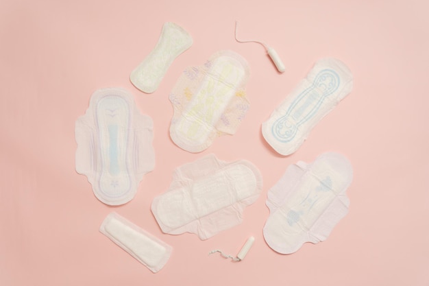 Verschiedene weibliche Handtücher, Hygienepolster mit Tampon auf rosa Hintergrund Menstruation