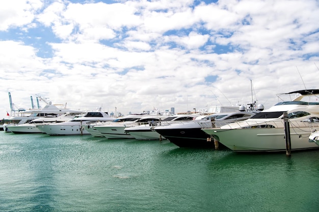 Verschiedene Yachten in Miami Marina Bay am Südstrand auf dem Wasser in der Bucht am sonnigen Tag mit Wolken am blauen Himmel