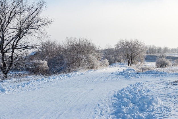 Verschneite Straße nach Schneefall. Winterlandschaft im ländlichen Raum