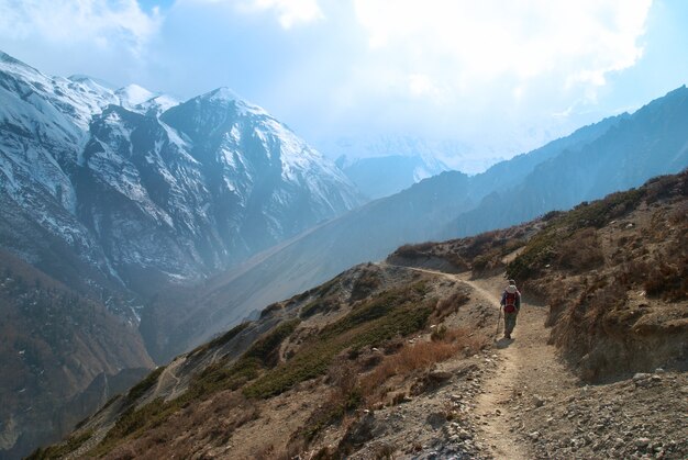 Verschneite tibetische Berge mit wanderndem Mann