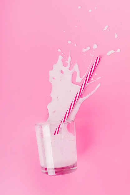 Foto verschüttetes milchshake auf rosa oberfläche