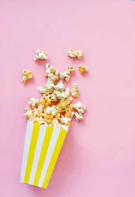 Verschüttetes Popcorn auf rosa Hintergrund Filmnachtkonzept Kopieren Sie Platz für Text